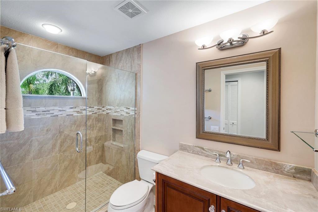 11426 Quail Village Way Naples, FL 34119 - Photo 24 of 46 a bathroom with a granite countertop sink toilet and shower