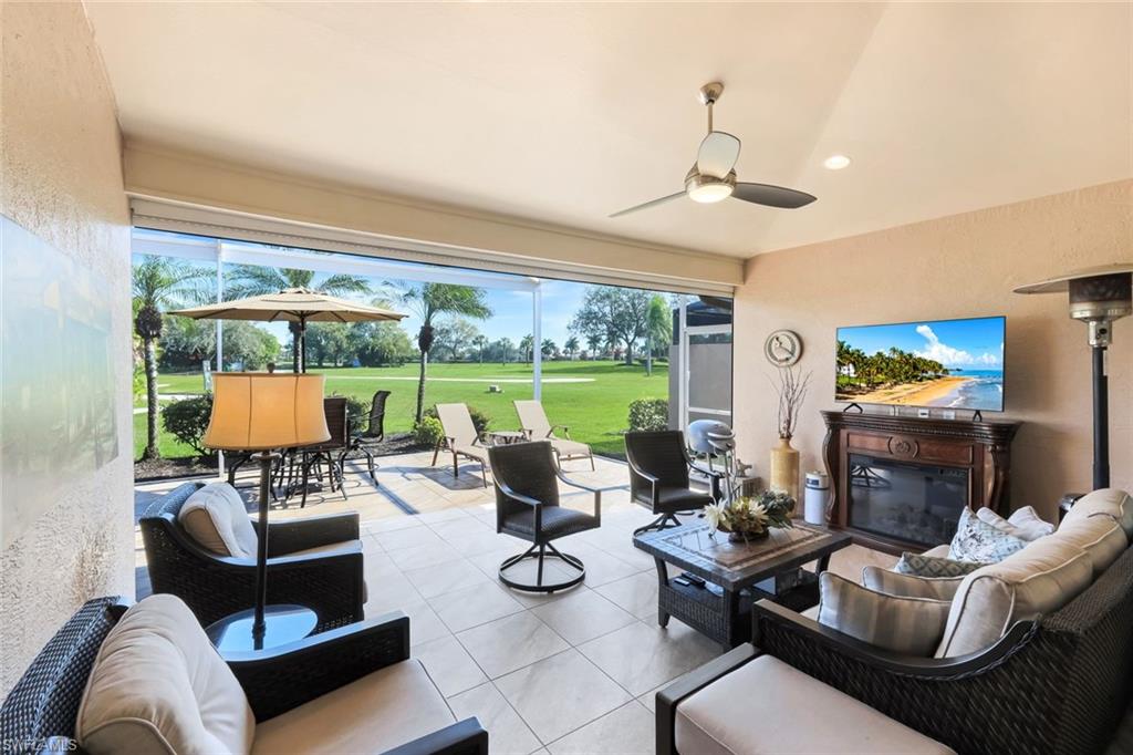 11426 Quail Village Way Naples, FL 34119 - Photo 29 of 46 a living room with furniture fireplace and large windows