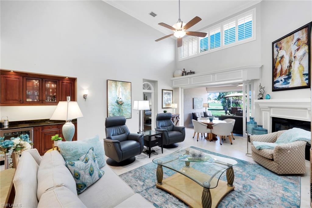 11426 Quail Village Way Naples, FL 34119 - Photo 3 of 46 a living room with furniture a fireplace and a large window