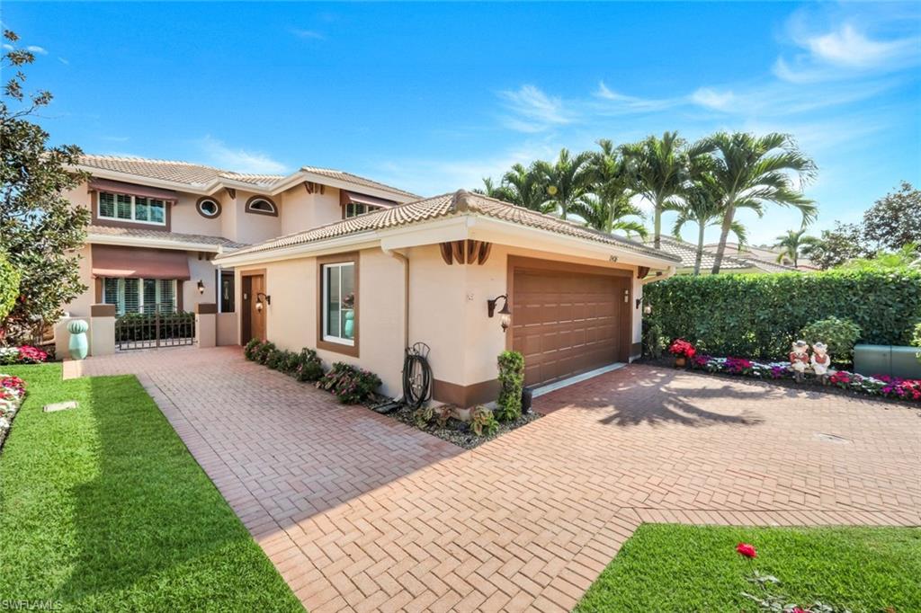 11426 Quail Village Way Naples, FL 34119 - Photo 34 of 46 a front view of a house with a yard and garage