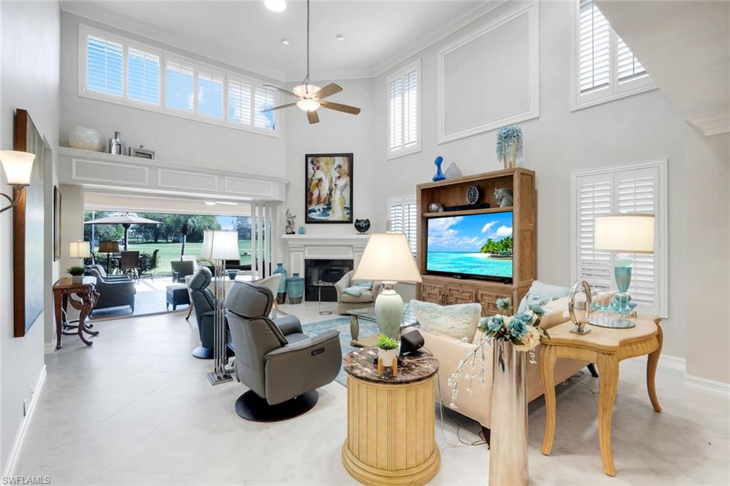 11426 Quail Village Way Naples, FL 34119 - Photo 4 of 46 a living room with furniture a fireplace and a flat screen tv