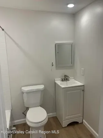 a bathroom with a toilet a sink and a mirror