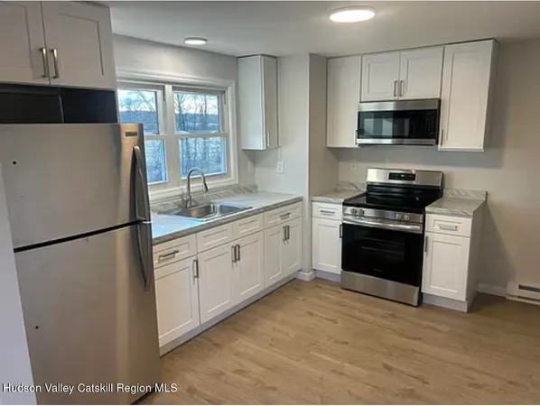 a kitchen with stainless steel appliances a refrigerator stove and microwave