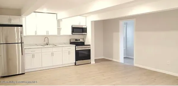 a kitchen with white cabinets and white appliances