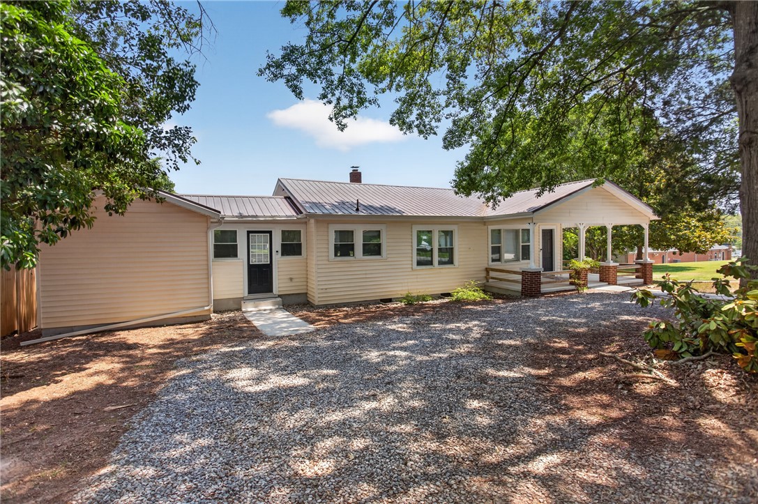 115 Pelfrey Street Seneca, SC 29672 - Photo 33 of 46 A charming single-story residence with a welcoming covered front porch, set amidst a generous gravel driveway.