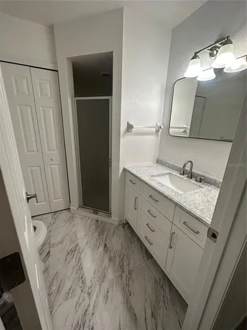 a bathroom with a granite countertop sink and a mirror