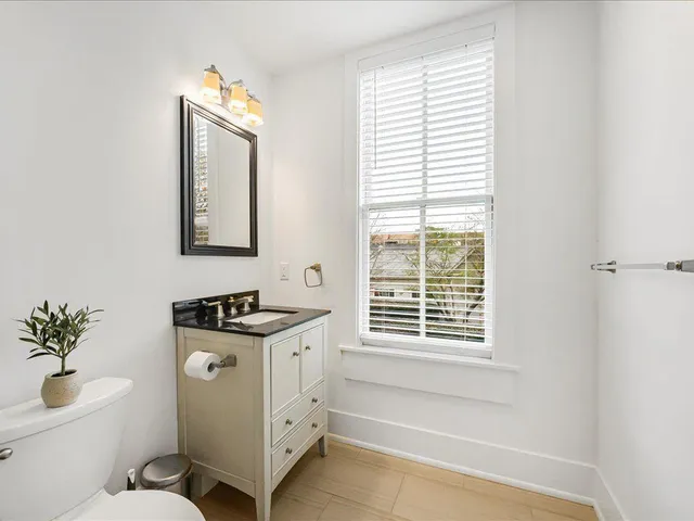 a bathroom with a toilet a sink and a window