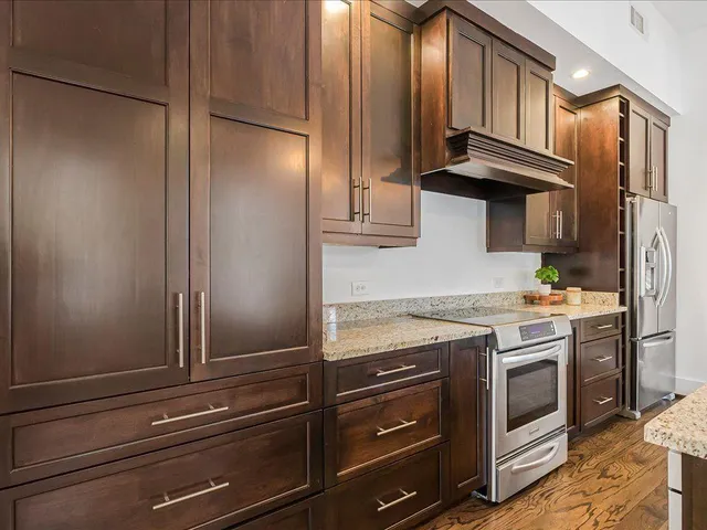 a kitchen with granite countertop a stove and a refrigerator