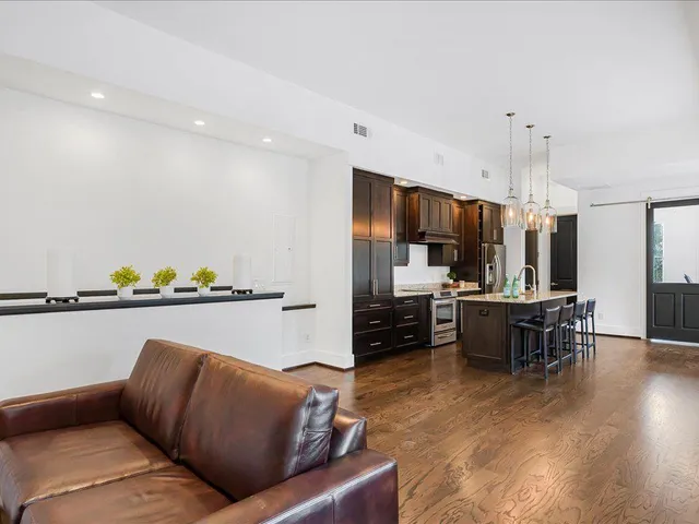 a living room with furniture kitchen view and a chandelier