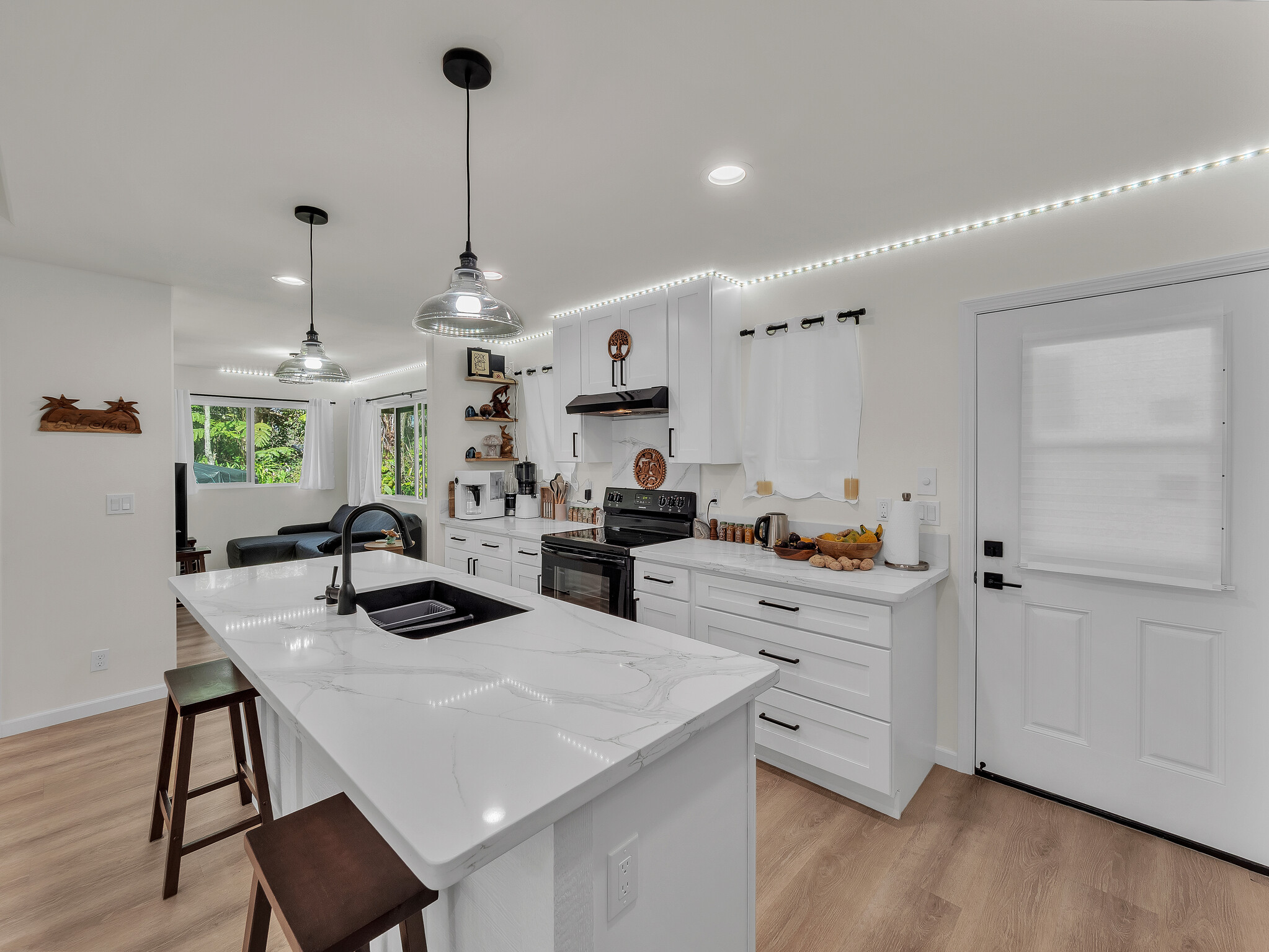 11-3976 Liona Street Volcano, HI 96785 - Photo 12 of 27 a kitchen with stainless steel appliances kitchen island granite countertop a table chairs and a refrigerator