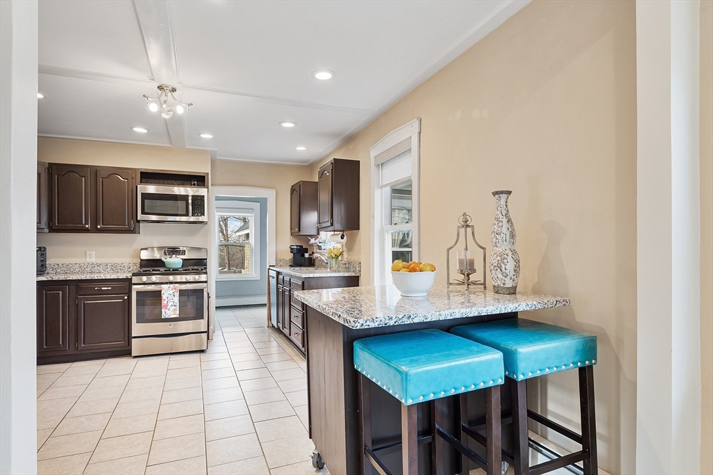 102 Centre Street Danvers, MA 01923 - Photo 9 of 36 a kitchen with stainless steel appliances granite countertop a stove top oven a sink dishwasher a dining table and chairs with wooden floor