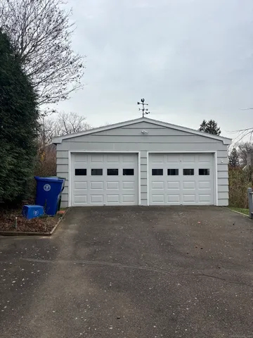 a front view of a house with parking space and a car parked in it