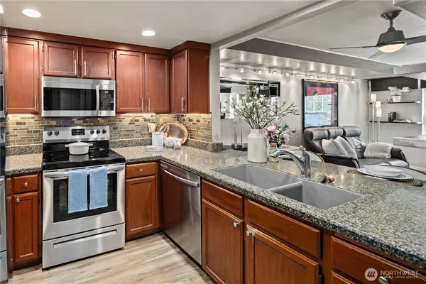 a kitchen with stainless steel appliances granite countertop a sink stove and microwave