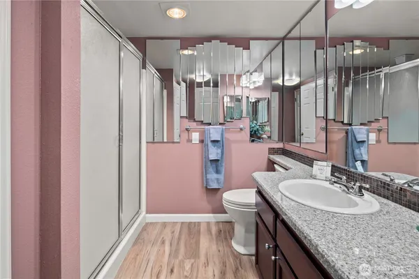 a bathroom with a granite countertop sink toilet and shower