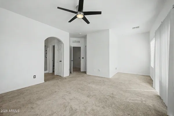 an empty room with chandelier fan