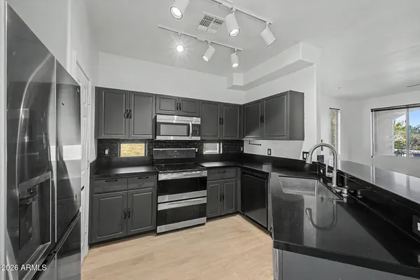 a kitchen with kitchen island a sink stainless steel appliances and cabinets