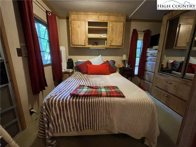 a bedroom with a bed and a flat tv screen on dresser