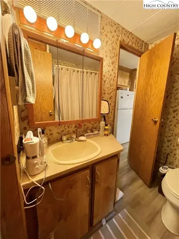 a bathroom with a sink and mirror with toilet