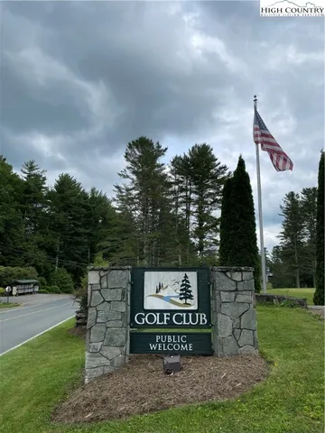 a view of a street sign under a large tree