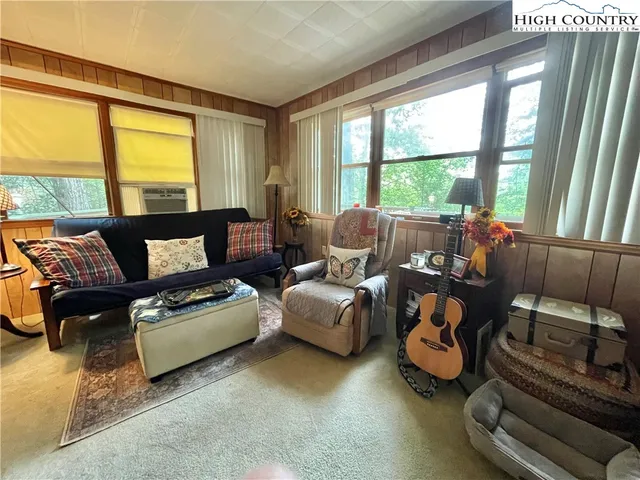 a living room with furniture and floor to ceiling windows