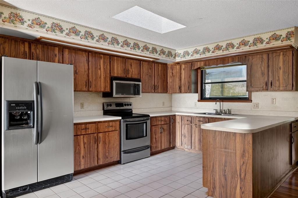 1620 Timbercrest Drive Deltona, FL 32738 - Photo 12 of 28 a kitchen with stainless steel appliances a sink cabinets and a window