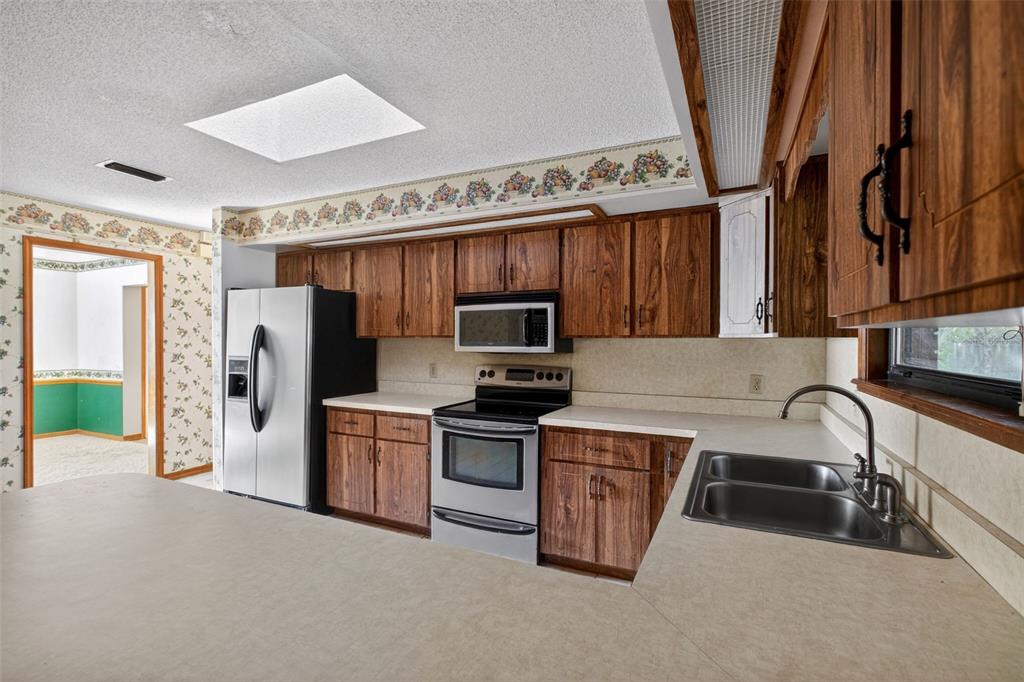 1620 Timbercrest Drive Deltona, FL 32738 - Photo 13 of 28 a kitchen that has a sink a stove and a refrigerator
