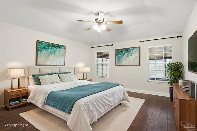a bedroom with a large bed a chandelier and a potted plant