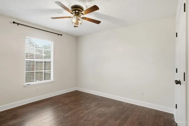 an empty room with a window and a fan
