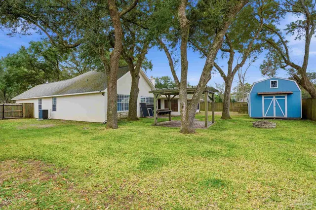 a view of a house with backyard and tree