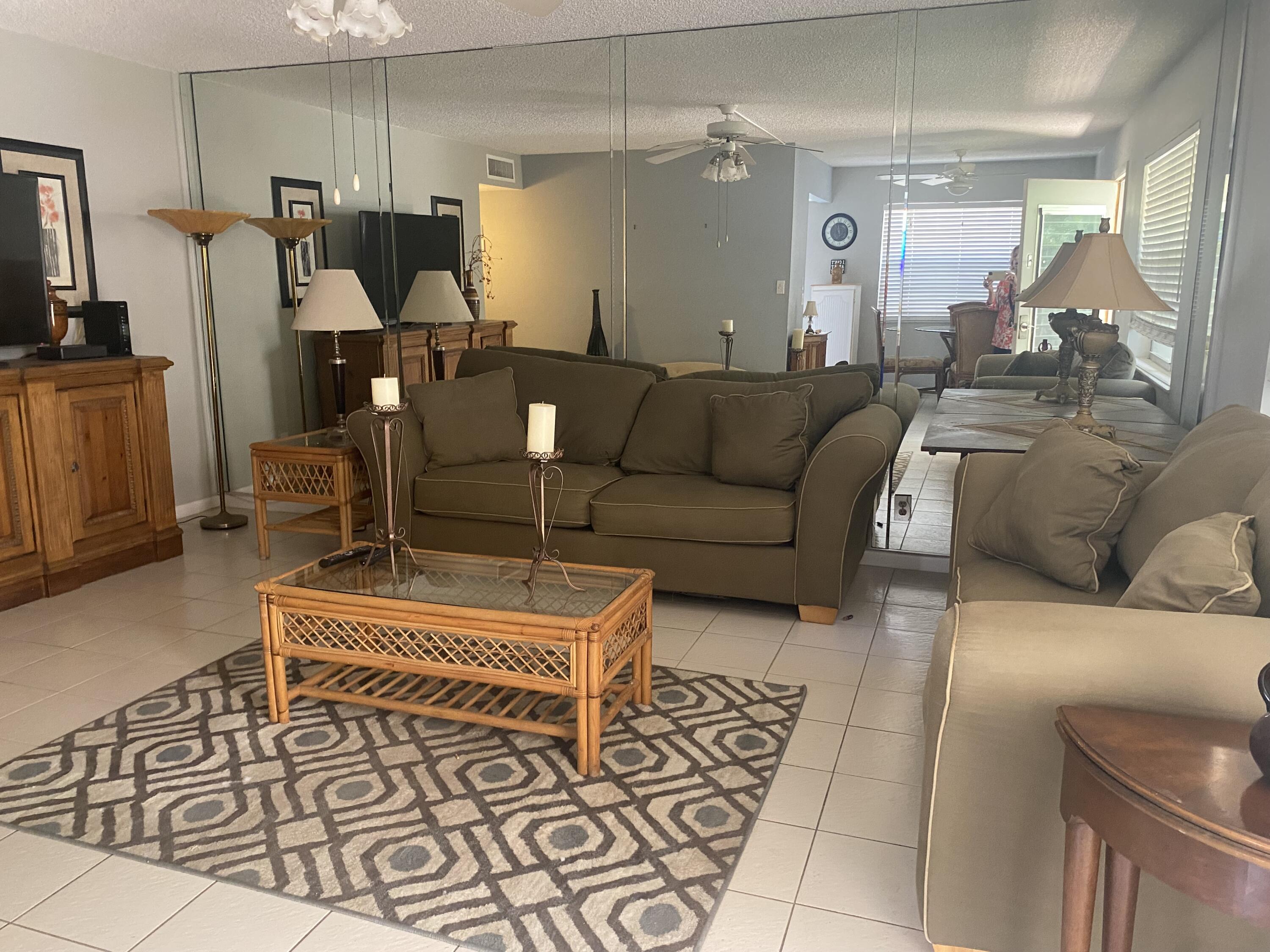 542 Normandy Lane, Unit 542 NORMANDY L Delray Beach, FL 33484 - Photo 1 of 41 a living room with furniture and a flat screen tv