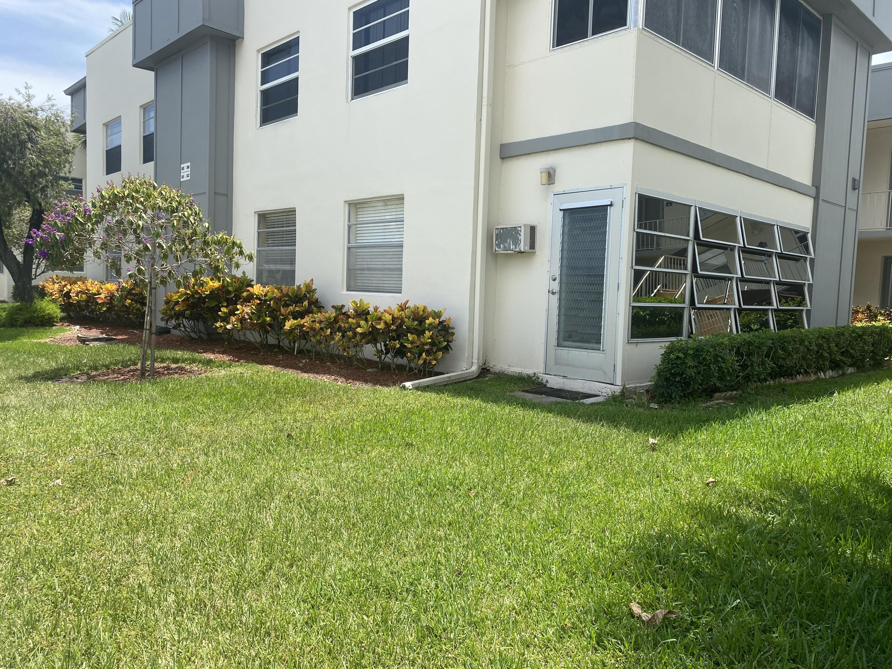 542 Normandy Lane, Unit 542 NORMANDY L Delray Beach, FL 33484 - Photo 16 of 41 a front view of a house with a garden