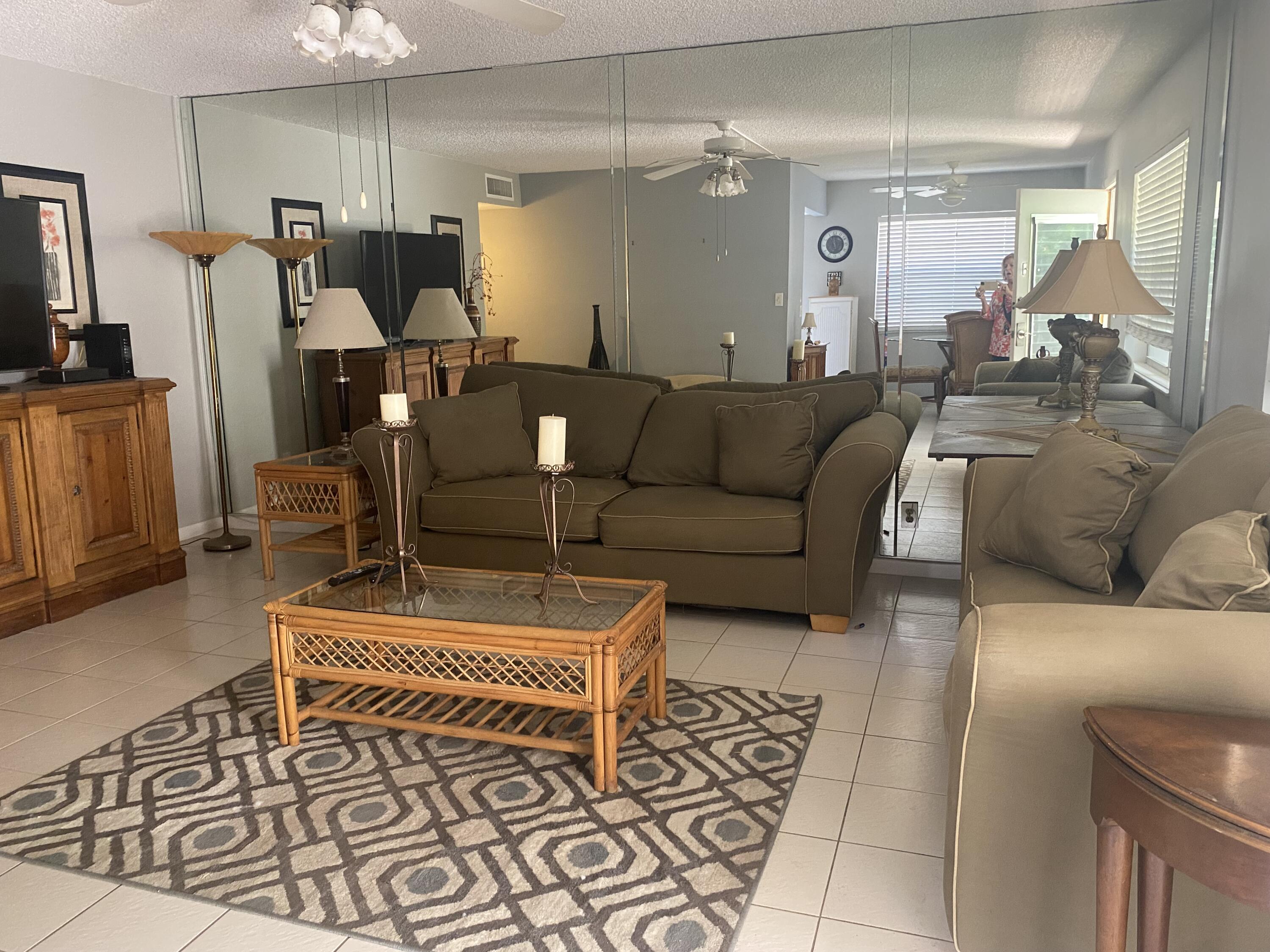 542 Normandy Lane, Unit 542 NORMANDY L Delray Beach, FL 33484 - Photo 3 of 41 a living room with furniture and a flat screen tv