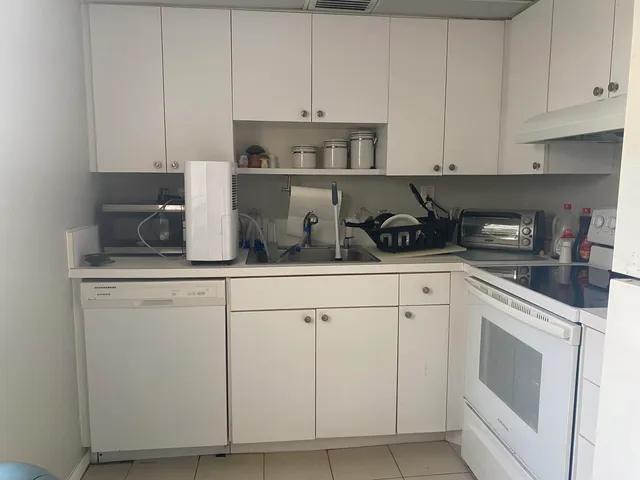 a kitchen with white cabinets and white appliances