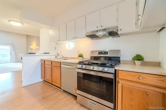 a kitchen with stainless steel appliances white cabinets and a stove top oven