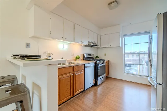 a kitchen with stainless steel appliances granite countertop a stove a sink and a refrigerator