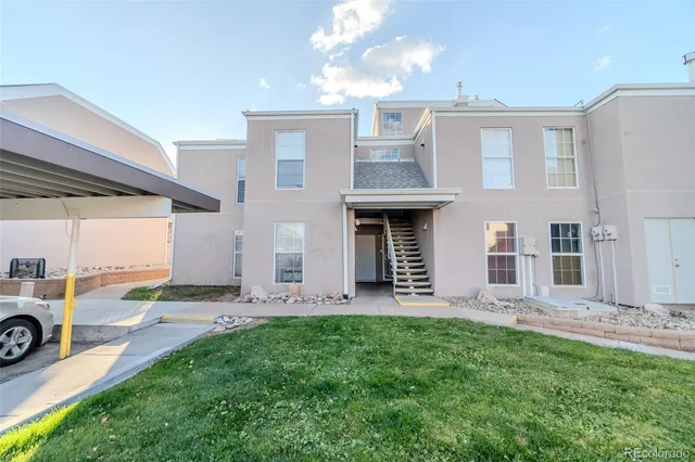 a view of a house with a yard and sitting area
