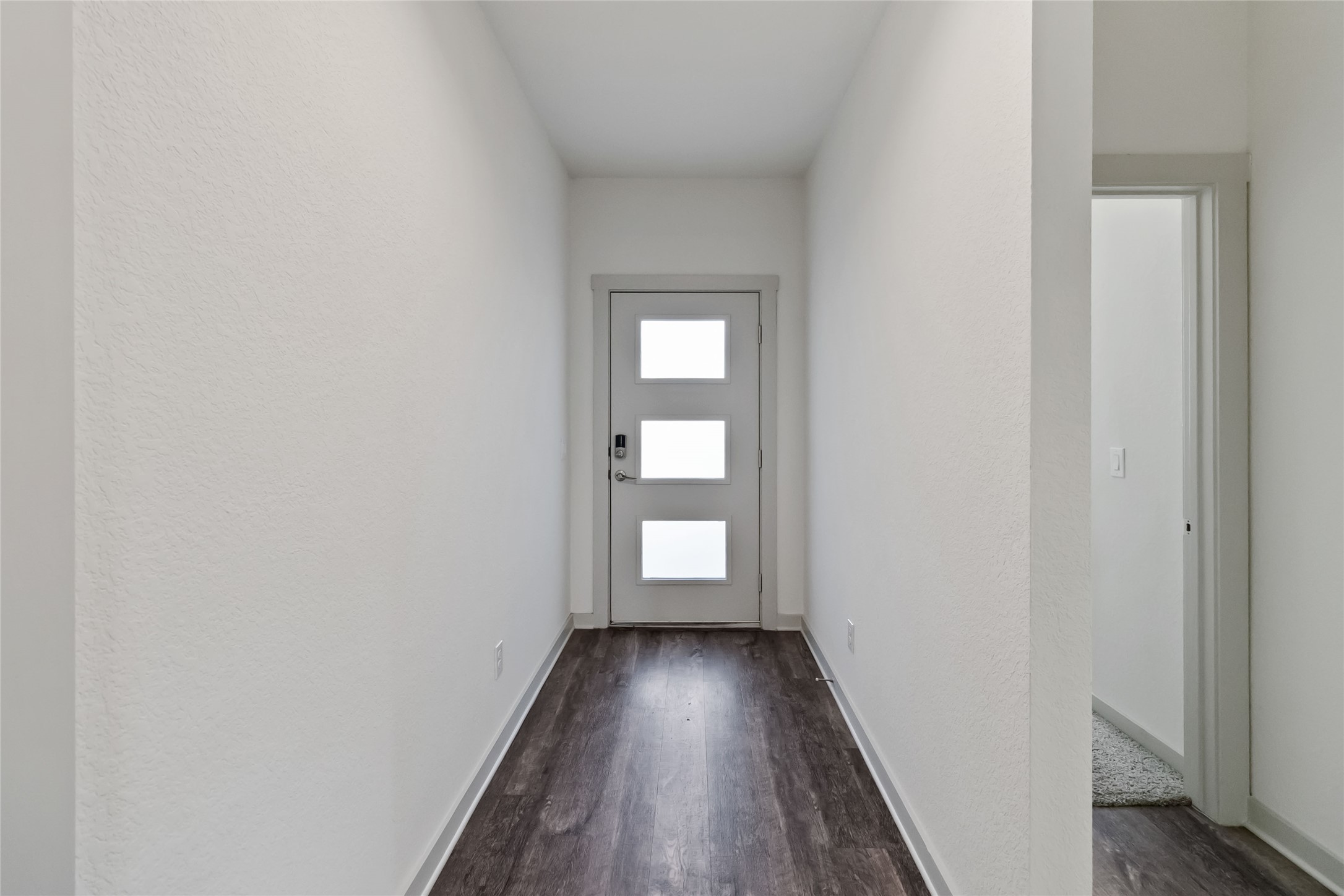 217 Deserti Road Leander, TX 78641 - Photo 6 of 31 Doorway featuring wood finished floors and a textured wall