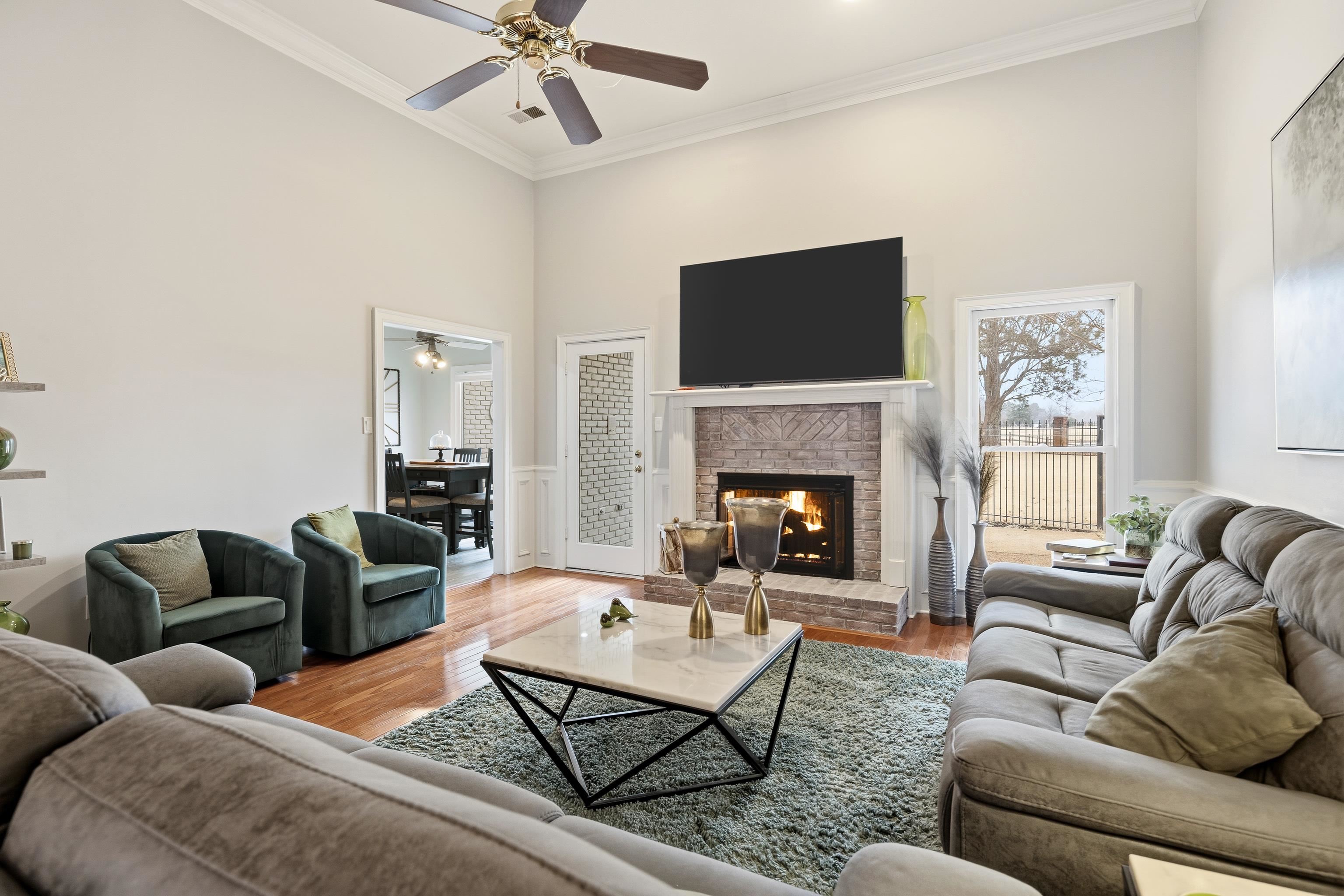 10281 Peyton Path Cove Collierville, TN 38017 - Photo 21 of 40 Living area with a high ceiling, wood finished floors, ornamental molding, ceiling fan, and a fireplace