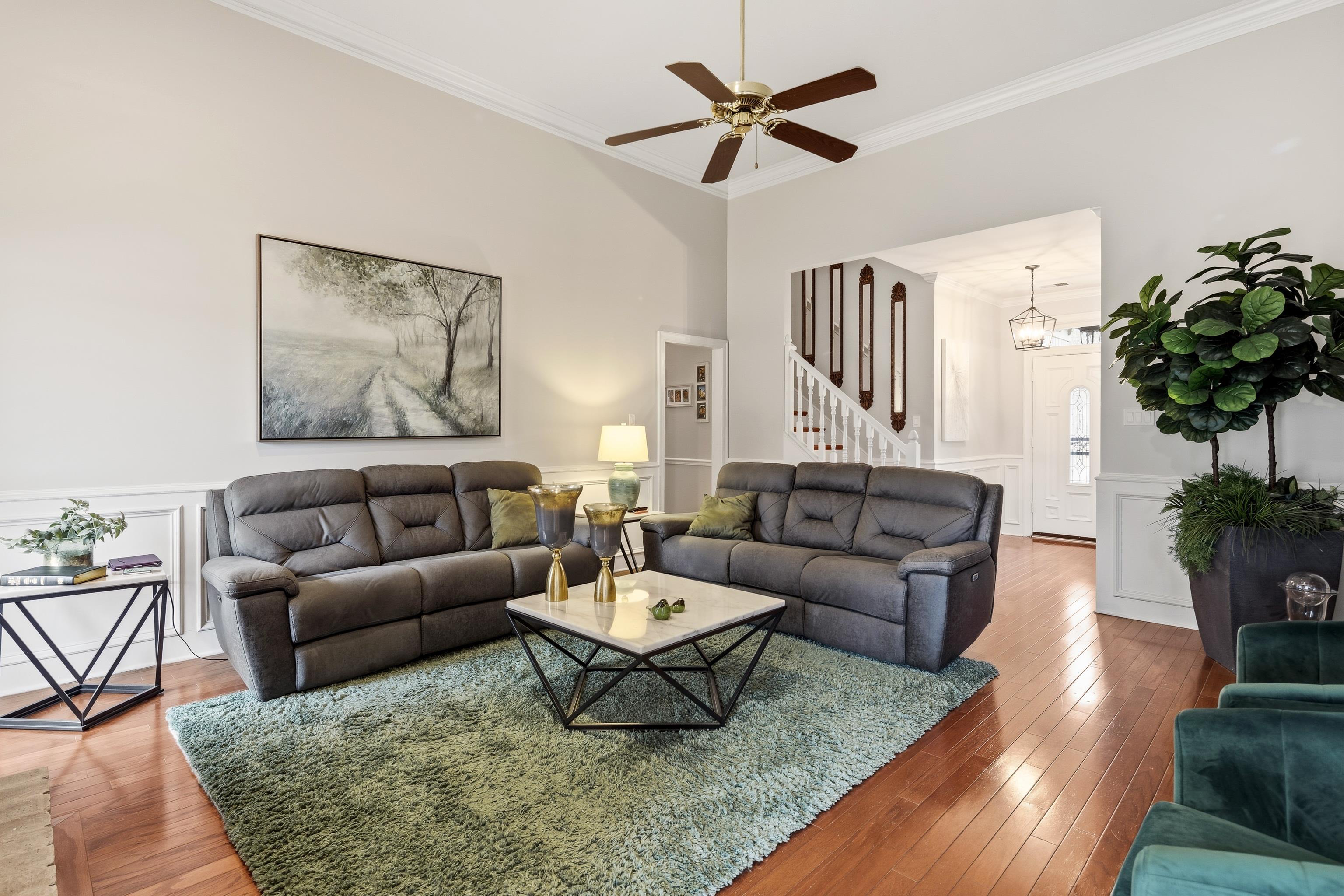 10281 Peyton Path Cove Collierville, TN 38017 - Photo 22 of 40 Living area with a decorative wall, wainscoting, crown molding, wood-type flooring, and a ceiling fan