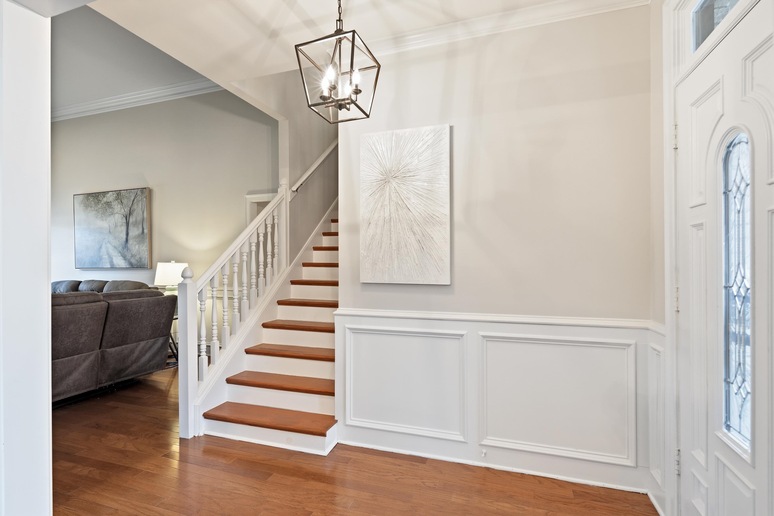 10281 Peyton Path Cove Collierville, TN 38017 - Photo 31 of 40 Entryway featuring crown molding, hanging lights, wood finished floors, plenty of natural light, and a wainscoted wall