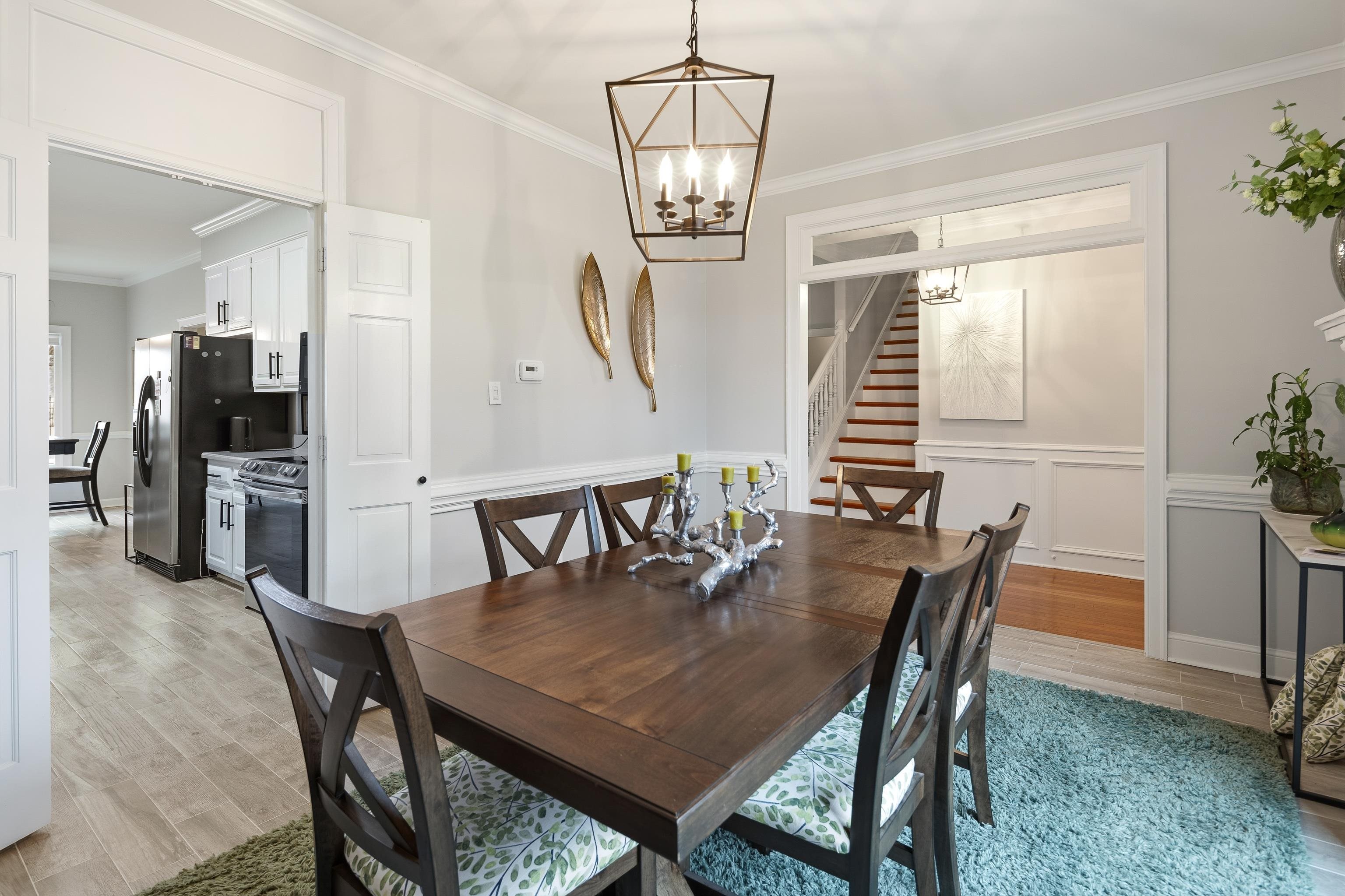 10281 Peyton Path Cove Collierville, TN 38017 - Photo 33 of 40 Dining space featuring crown molding, light wood-style flooring, a chandelier, wainscoting, and a decorative wall
