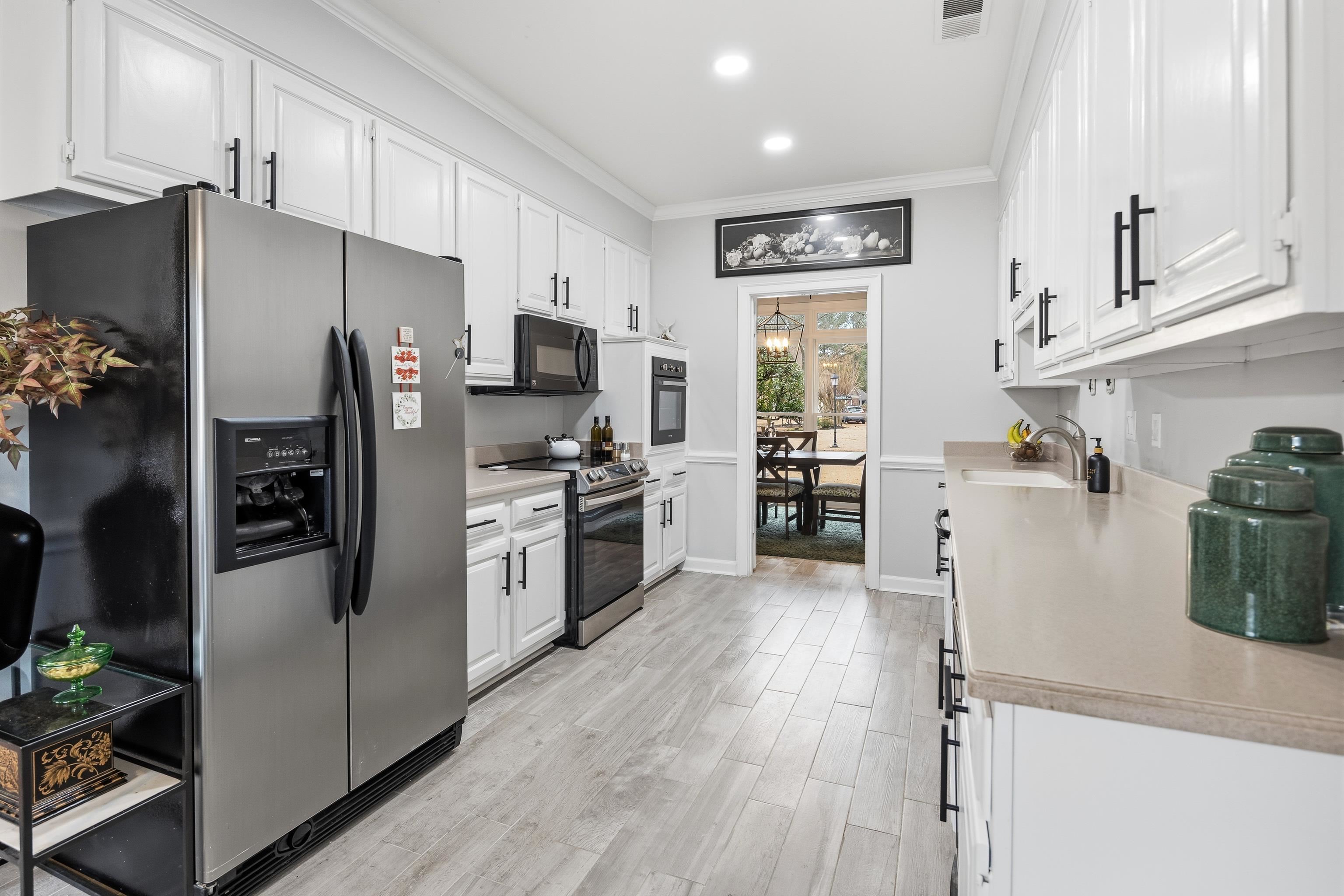 10281 Peyton Path Cove Collierville, TN 38017 - Photo 34 of 40 Kitchen featuring white cabinetry, black appliances, light countertops, ornamental molding, and recessed lighting