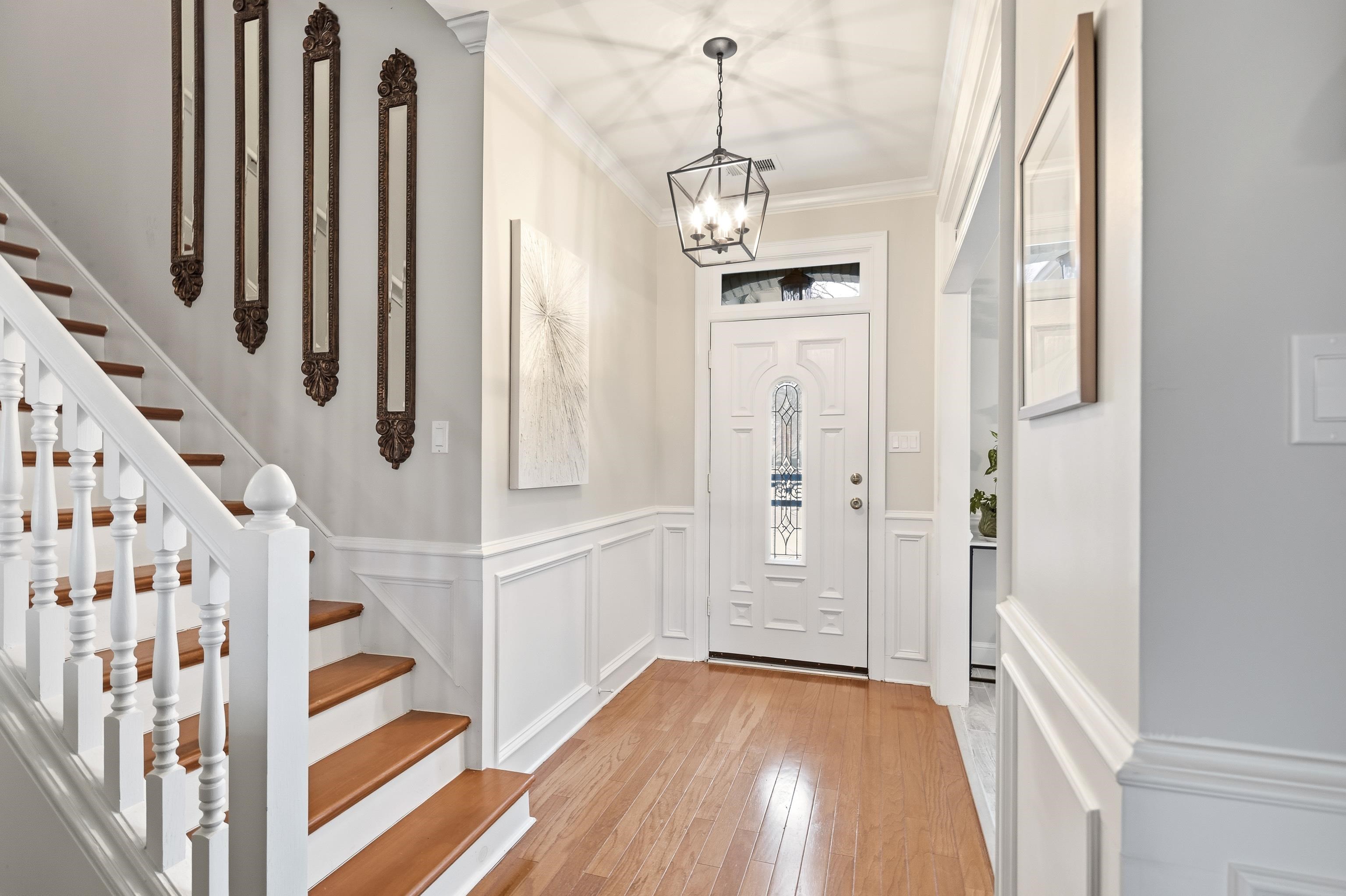 10281 Peyton Path Cove Collierville, TN 38017 - Photo 5 of 40 Entrance foyer featuring wainscoting, a decorative wall, light wood finished floors, ornamental molding, and a chandelier