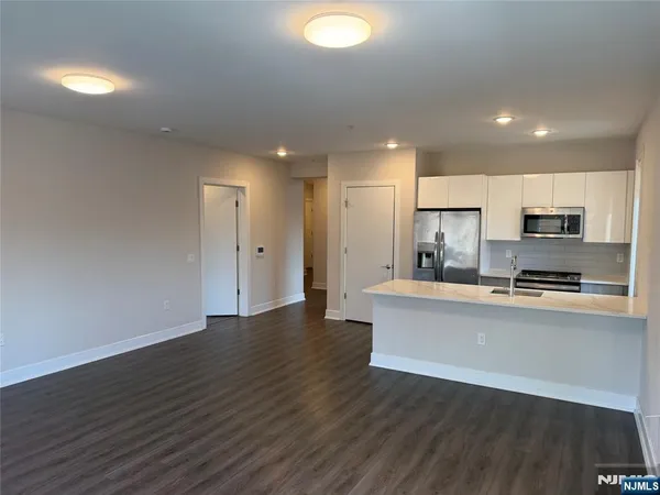 a view of kitchen with stainless steel appliances refrigerator stove microwave and cabinets