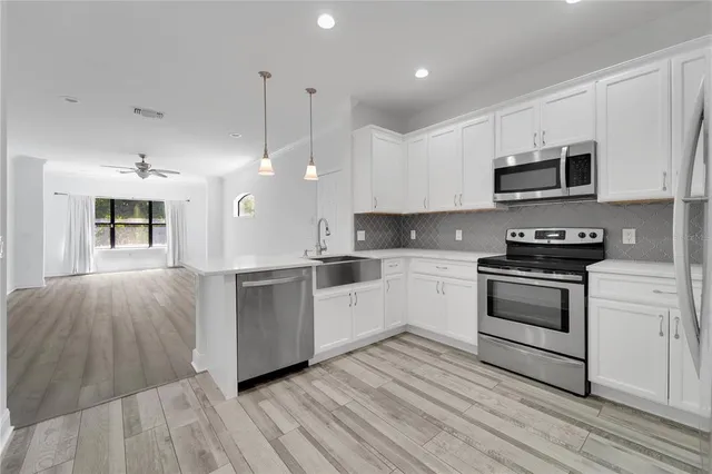 a kitchen with a white stove top oven and white cabinets