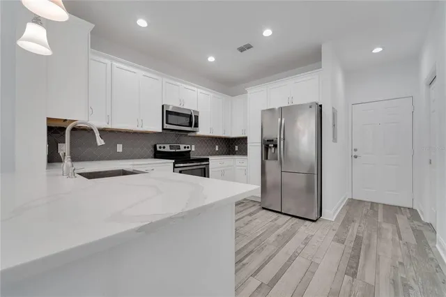 a kitchen with stainless steel appliances a refrigerator and a stove top oven