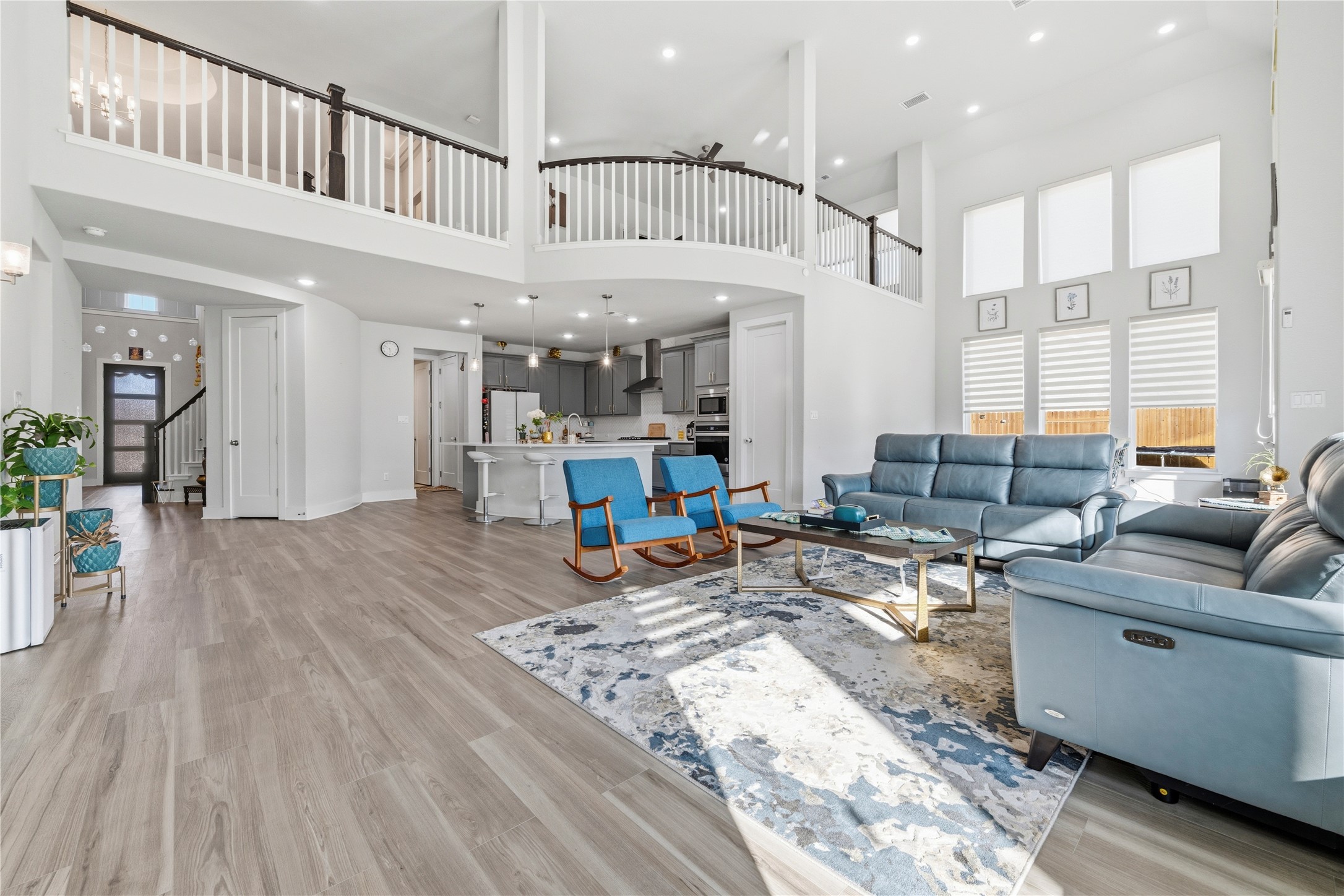 105 Autumn Oak Way Georgetown, TX 78628 - Photo 8 of 40 Open-concept living area featuring high ceilings, wood-finish flooring, and multiple large windows