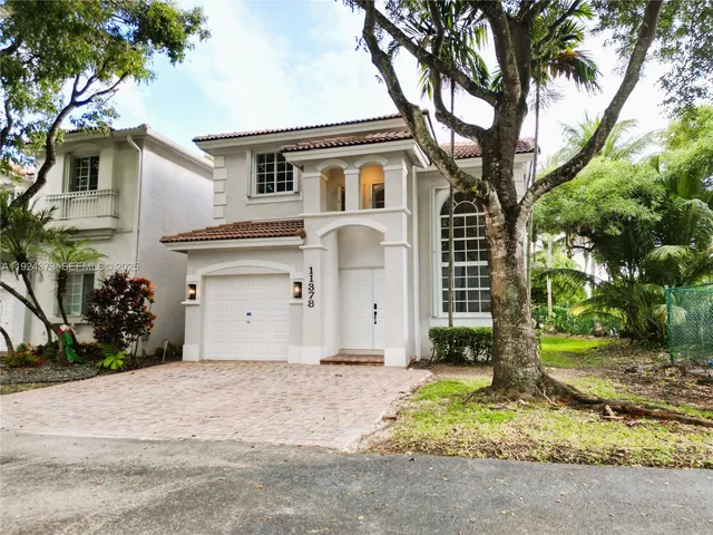 a white house that has a tree in front of it