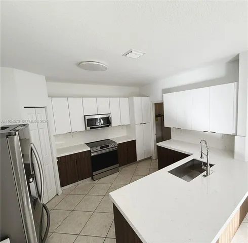 a kitchen with stainless steel appliances a sink stove and refrigerator