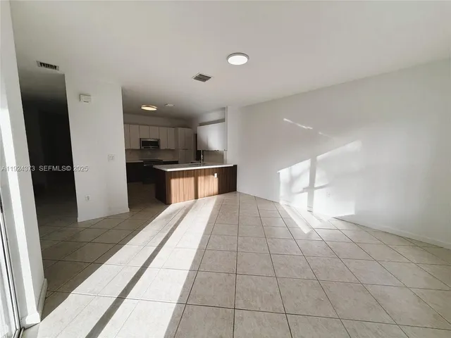 a view of a kitchen with a sink and a refrigerator